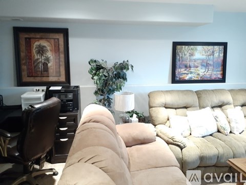 A living room with a beige couch and a brown chair.