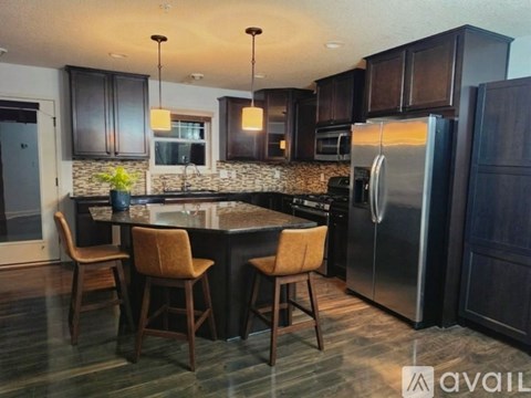 A kitchen with a table and chairs and a refrigerator.