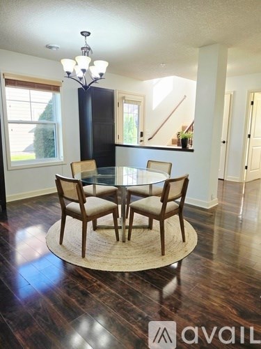 A dining room with a glass table and chairs.