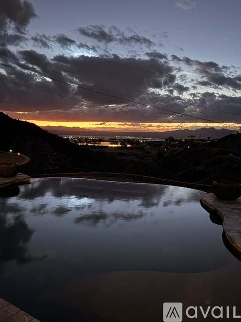 A pool with a view of the city at dusk.