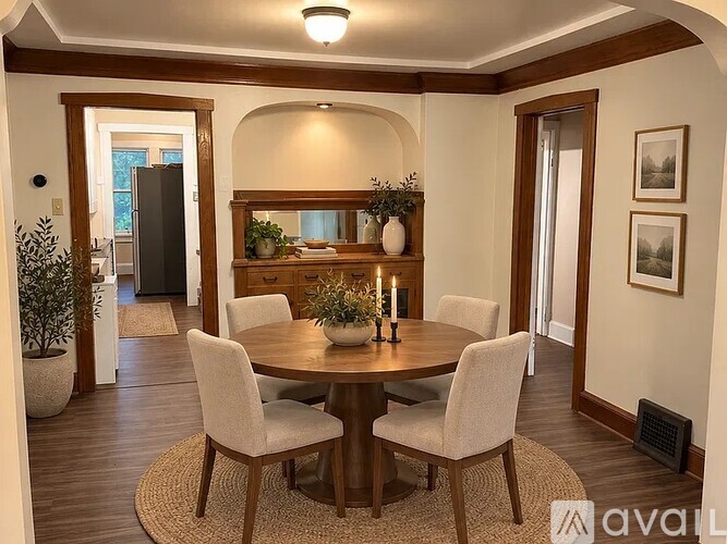 A dining room with a round table and chairs.