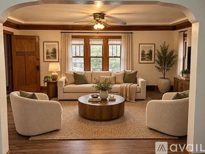 A living room with a white sofa set and a wooden coffee table.