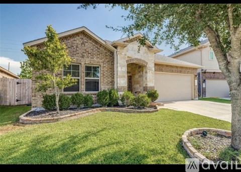 A house with a front yard and a tree.
