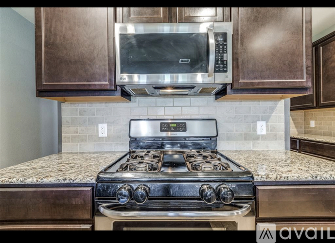 A modern kitchen with a stove top oven and microwave above it.