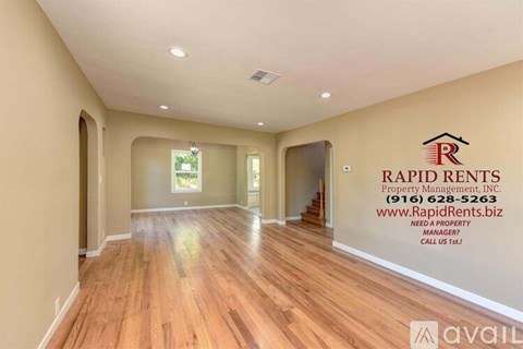 A spacious room with Rapid Rents Property Management logo and contact information on the wall.