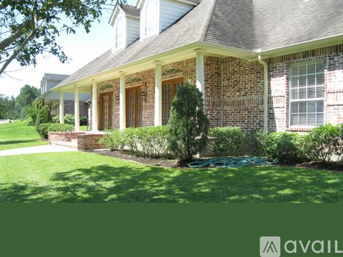 A house with a green lawn and a hose in the front yard.