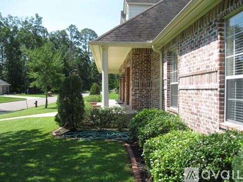 A house with a white porch and a green lawn.