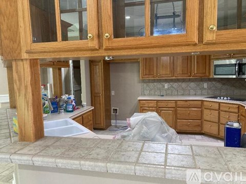 A kitchen with wooden cabinets and a countertop covered in plastic.