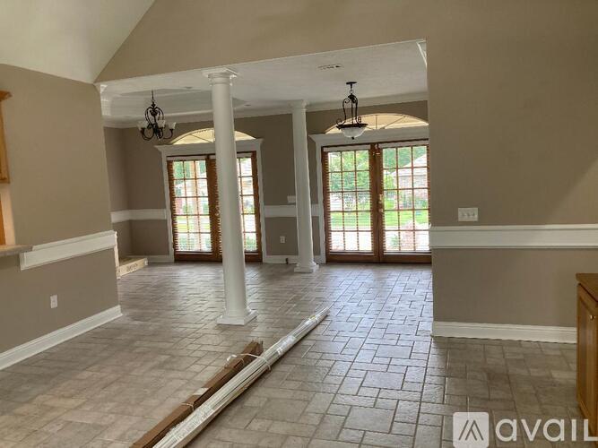 A spacious room with tiled flooring and a large window.
