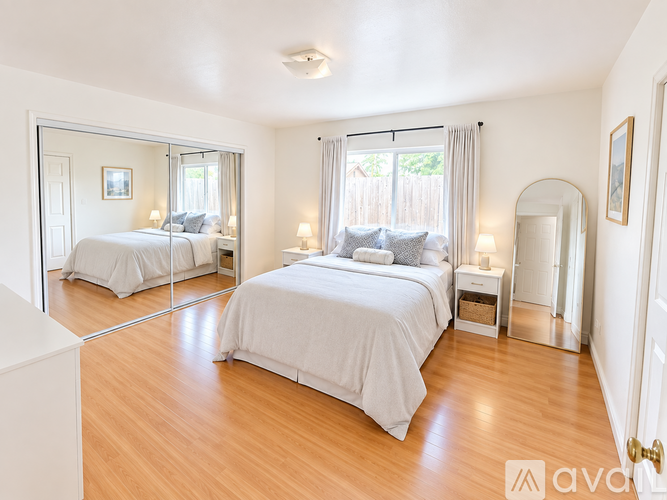 A bedroom with a large bed and a mirror on the wall.