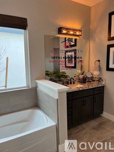 A bathroom with a tub and a window.