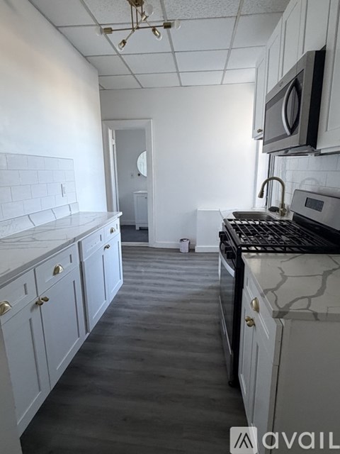 A kitchen with white cabinets and a black stove top oven.