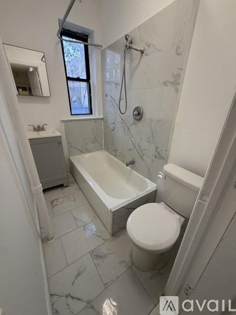 A bathroom with a marble floor and white walls.