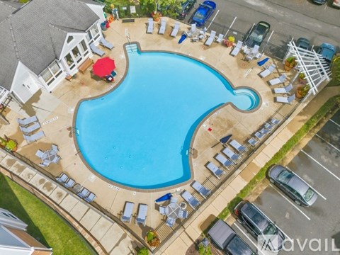 An aerial view of a pool surrounded by lounge chairs and umbrellas.