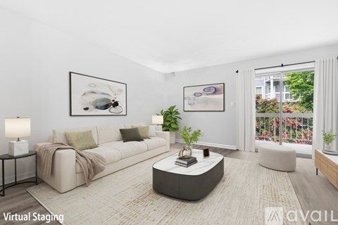 A living room with a white couch, a coffee table, and two framed pictures on the wall.