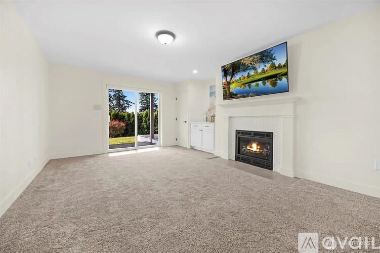 A living room with a fireplace and a television displaying a landscape.