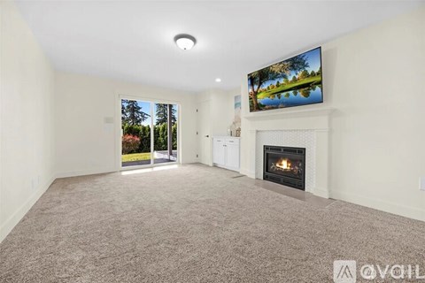 A living room with a fireplace and a television displaying a landscape.