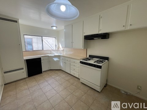 A kitchen with white cabinets and a black dishwasher.