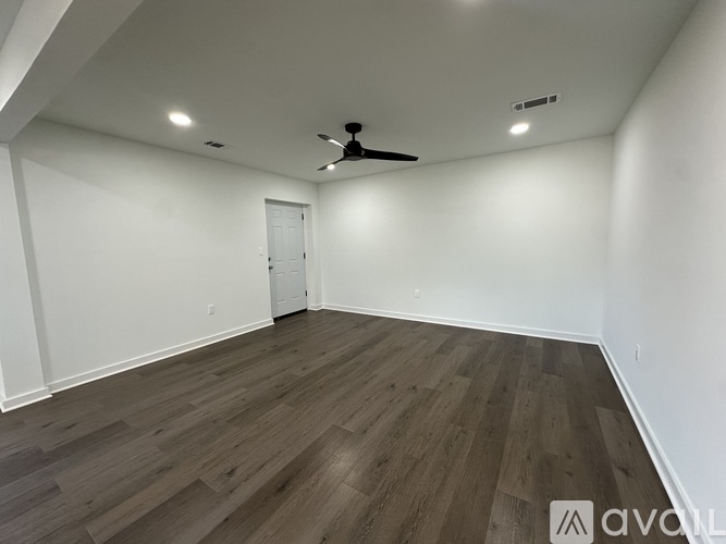 A room with wooden flooring and a ceiling fan.