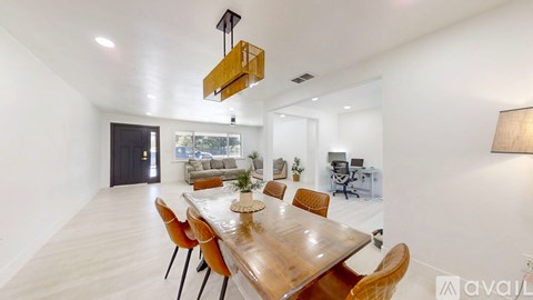 A modern dining room with a wooden table and chairs.