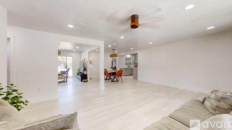A living room with a couch and a ceiling fan.