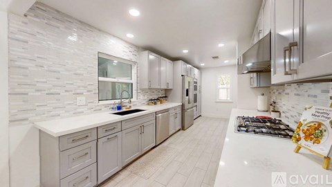 A modern kitchen with white cabinets and a marble countertop.