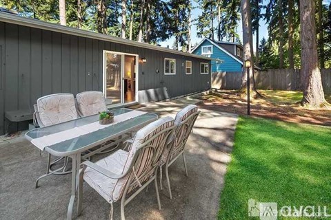 A backyard with a table and chairs.