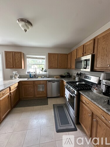 A kitchen with wooden cabinets and a stainless steel oven.