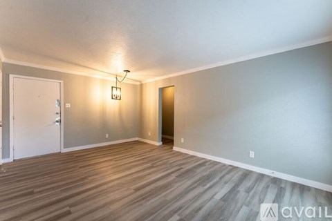 A room with wooden flooring and a light on the wall.