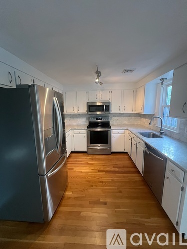 A kitchen with wooden floors and stainless steel appliances.