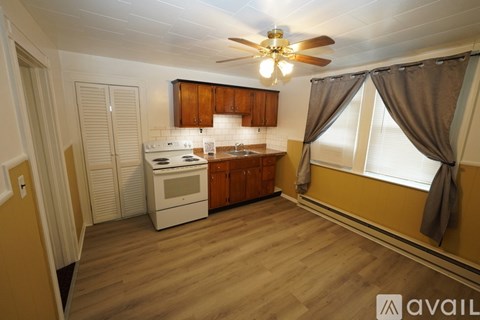 A kitchen with wooden cabinets and a white stove top oven.