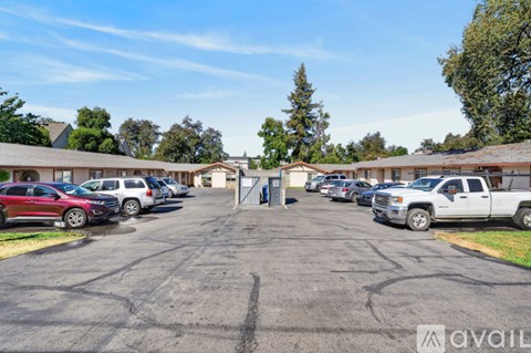 A parking lot with cars and a building in the background.