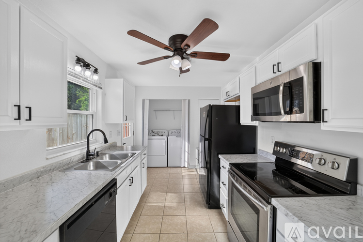 A kitchen with a black oven and white cabinets.