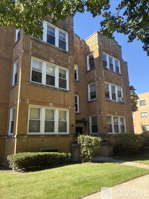 A brick building with a green lawn in front.
