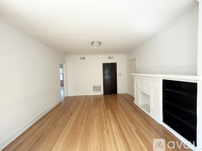 A room with wooden floors and a fireplace.