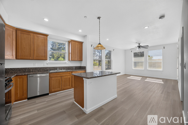 A kitchen with wooden cabinets and a white island.