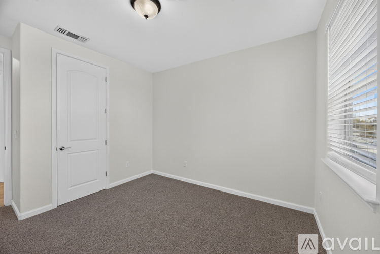 A room with a white door and carpeted floor.
