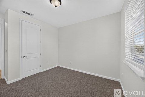 A room with a white door and carpeted floor.