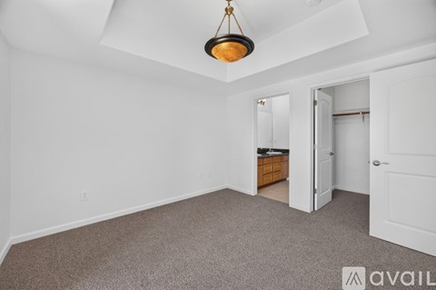 A room with a carpeted floor and a hanging light fixture.