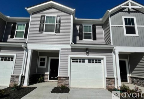 A two-story house with a garage is available for sale.