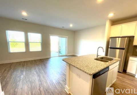 A kitchen with a granite countertop and wooden flooring.