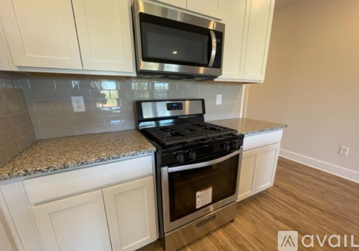 A kitchen with a black stove top oven and a microwave above it.