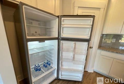 A white refrigerator with its door open in a kitchen.