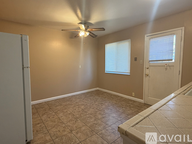 A room with a ceiling fan and tile flooring.