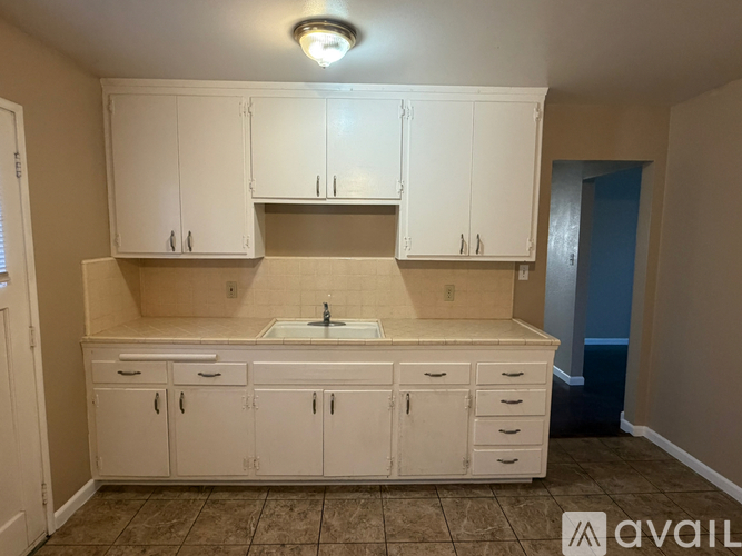 A kitchen with white cabinets and a sink.