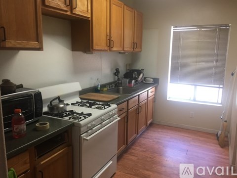 A kitchen with wooden cabinets and a white stove top oven.