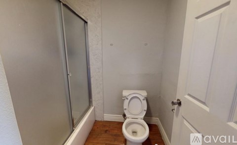 A white toilet in a small bathroom with a door to the left and a door to the right.
