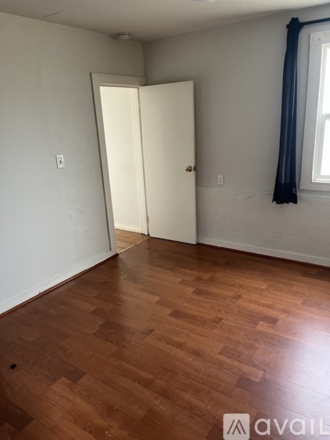 A room with a wooden floor and a white door.