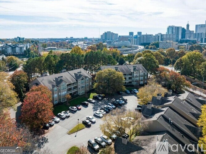 A bird's eye view of a parking lot with cars and apartment buildings.