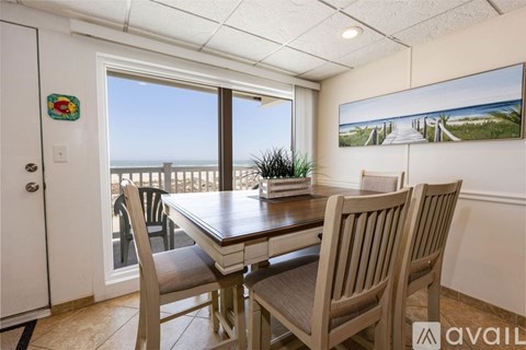 A dining room with a wooden table and chairs.